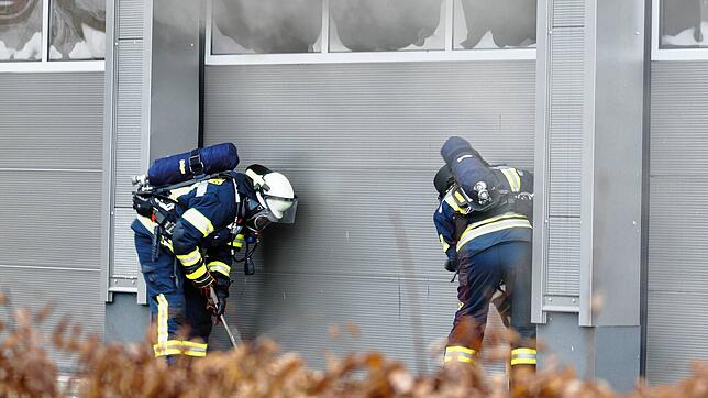 Aus einer Lagerhalle in der Raiffeisenstraße dringt Rauch: Das ruft die Feuerwehr am Silvestertag zu einem Einsatz. Zwei Feuerwehrleute ...