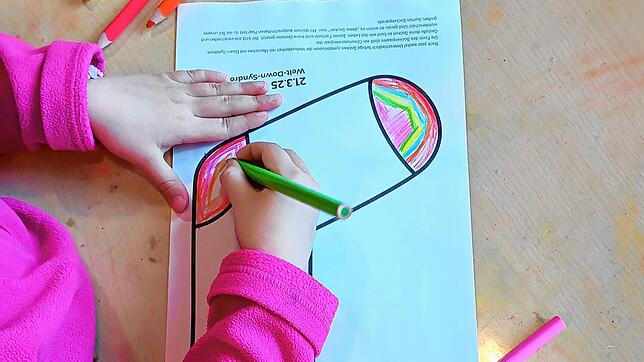Ein Kind malt in der Kita eine Socke aus Papier bunt an. Foto: Stadt Singen