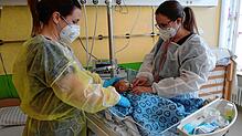 Anja Wernet, Gesundheits- und Kinderkrankenpflegerin und Assistenzärztin Simone Köhler (rechts) untersuchen ein zwei Wochen altes Baby, ...
