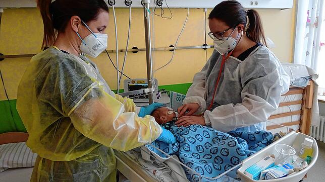 Anja Wernet, Gesundheits- und Kinderkrankenpflegerin und Assistenzärztin Simone Köhler (rechts) untersuchen ein zwei Wochen altes Baby, ...