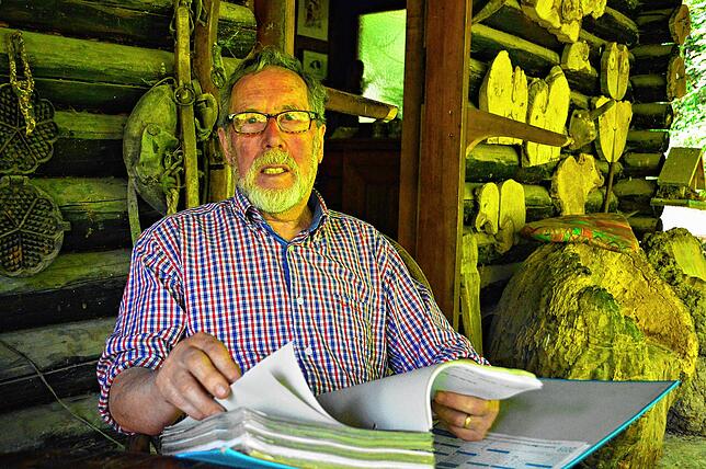 Eberhard Wirth blättert in Ordnern, in denen er jedes Jahr auf der Fuchsfarm dokumentiert hat.
