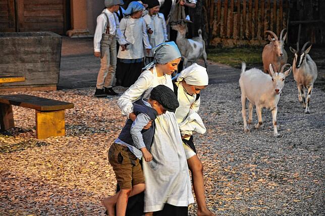 Eine Szene mit Kindern und Ziegen bei den Freilichtspielen „Zwischen den Welten“ im Klostergarten Riedern.