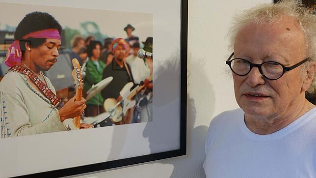 Kurator Reinhard Schultz vor einem Foto von Jimi Hendrix in der Ausstellung &bdquo;50 Jahre Woodstock&ldquo; in der Villa Berberich.