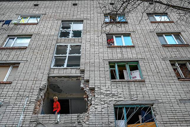 Eine Frau schaut aus einem zerstörten Haus in Mykolajev im Süden der Ukraine.