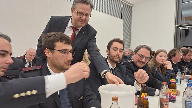 Ein gut gelaunter Wahlleiter: Bürgermeister Henrik Wengert beim Einsammeln der Stimmzettel bei der Hauptversammlung der Feuerwehr.