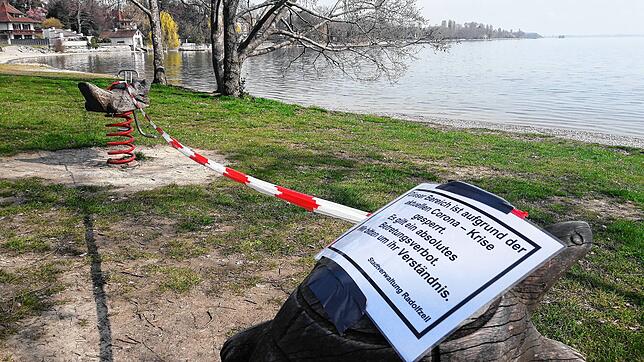 Bitte nicht wippen: Absperrband und Schild am Seeufer weisen darauf hin – das Spielgerät darf nicht benutzt werden.