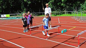 Den Hürdenlauf vorbereiten, da betritt Trainer Max Leutzbach mit den Grundschulkindern Neuland. Fotos: Gerd Leutenecker