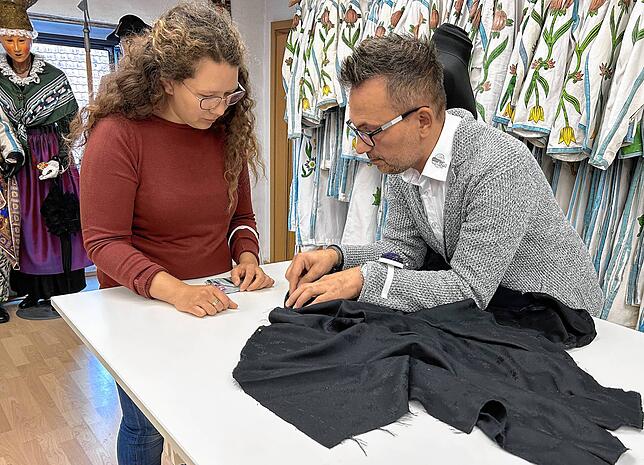 Manuel Rausevic beschreibt Jennifer König die Besonderheiten beim Nähen des Morbili-Kleides.