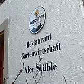Die Außenfassade des Gebäudes. Schild, Schrift und Namenszug bleiben so erhalten.