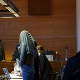 Der Angeklagte Christian L. bedeckt sein Gesicht zum Schutz vor den Kameras mit einer Jacke.