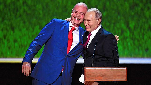 Wladimir Putin (rechts) und Gianni Infantino, FIFA-Präsident, umarmen sich am Vorabend des Fußball-WM-Finalspiels vor einem Galakonzert ...