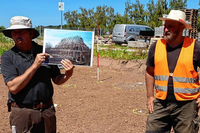 Kreisarchäologe Jürgen Hald (links) zeigt hier ein Foto eines Gebäudes in der Art, wie es ähnlich auch auf dem Gelände in Beuren an der ...