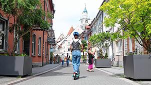 Eine Frau fährt mit einem E-Roller in der Überlinger Münsterstraße.
