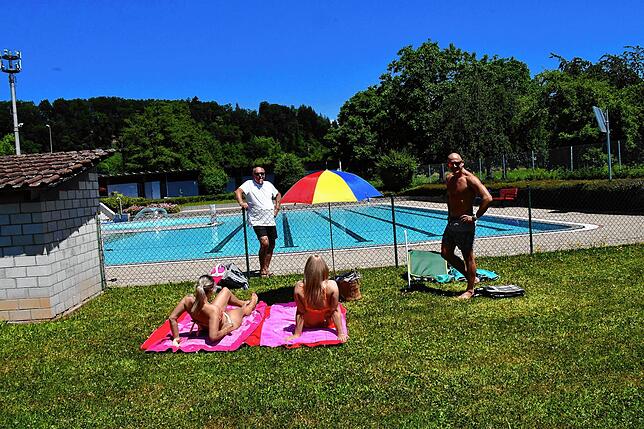 Schwimmmeister Dieter Bless – im Bild hinten links (weißes T-Shirt) im Gespräch mit Badegästen – hegt und pflegt das Freibad ...