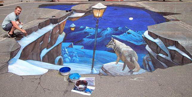 Auf dem Blumberger Marktplatz malte Nikolaj Arndt 2017 das große 3D-Bild von einem Wolf inmitten einer Winterlandschaft. Bild: Bernhard Lutz
