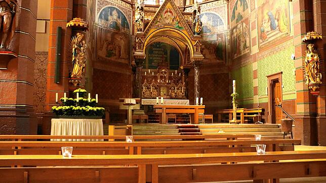 Die Plätze für die Gottesdienstbesucher werden in der katholischen Kirche durch brennende Kerzen markiert. Bild: Martha Weishaar