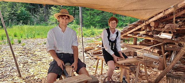 Gabriel Brodbeck (links) und Nils Küchle fertigen Holznägel an, die für die Dachschindeln benötigt werden.