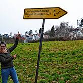 Edith Heppeler zeigt voller Vorfreude auf den Wegweiser, der am ehemaligen Haupteingang des Uferparks steht. 66 Kilometer Luftlinie ...