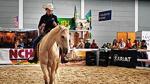 Eine Reiterin zeigt bei der Americana, wie Horsemanship funktioniert, und lenkt ihr Pferd souverän im Westernsattel ganz ohne Trense.