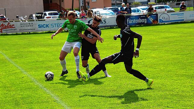 Der Donaueschinger Yannick Bartmann (grünes Trikot) versucht sich in der Szene gleich die zwei Stockacher Lamion Badjie (rechts) und ...
