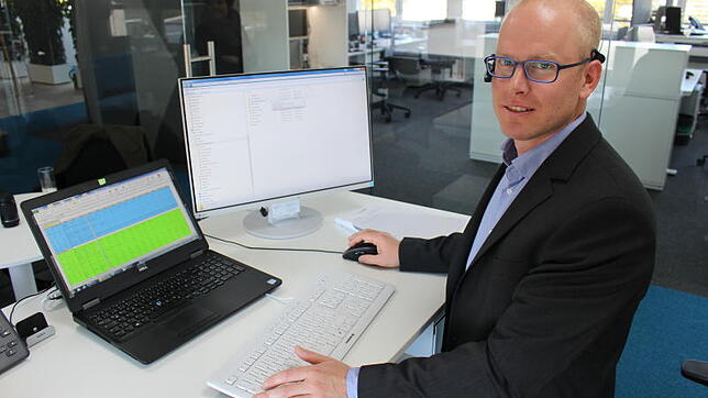 Simon Brugger an seinem Arbeitsplatz bei der Sick AG: Höhenverstellbarer Tisch, transparente Außenwände und eine offene Büroatmosphäre ...