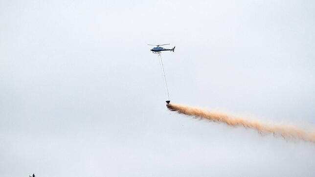 Ein Hubschrauber wirft Kalk über einem Wald ab. Dies soll Folgen des sauren Regens mildern. Foto: Hans-Jörg Hellwig/stock.adobe
