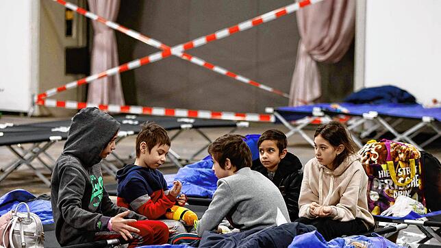 Kinder aus Ukraine spielen auf Feldbetten in einem abgesperrten Bereich in der Messe Berlin. Sie sollen bald in Deutschland zur Schule ...