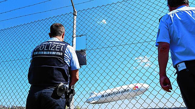 Zwei Polizisten verfolgen am Karfreitag vom Zaun aus den Start des Zeppelin NT.