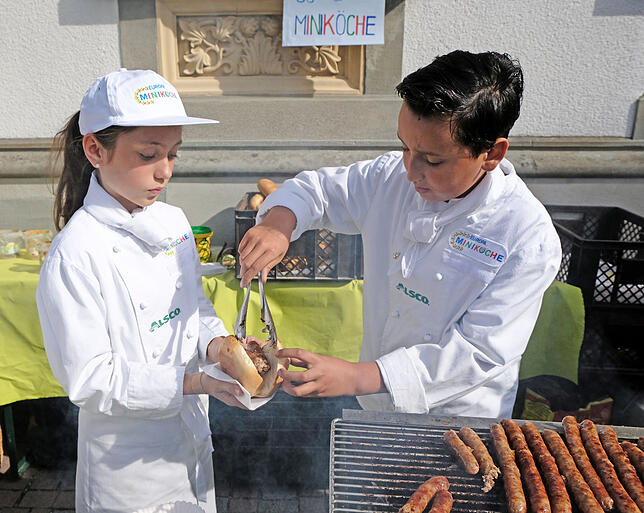 Franka und Kaan von den Miniköchen kredenzen den Besuchern frische Grillwürstchen – mit klassischem Senf oder mit Zwetschgenketchup.