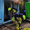 Feuerwehrleute vor dem qualmenden Baucontainer am Fährgelände der Stadtwerke.