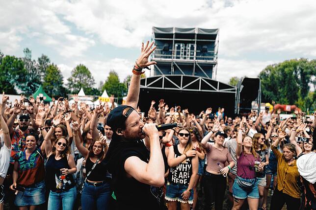 Querbeat-Sänger Jojo Berger heizt das Publikum bei einem Open-Air-Konzert ein.