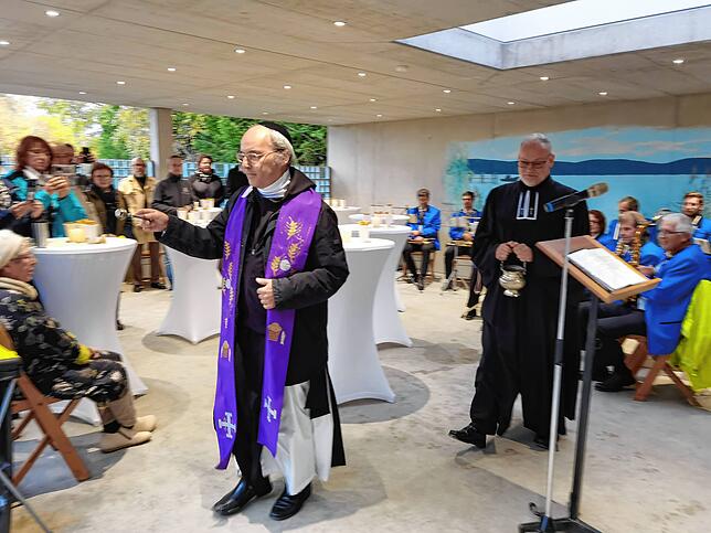Pater Bruno Metzler (vorne) und Pfarrer Kai Tilgner segnen die neue Trauerstätte auf dem Nußdorfer Friedhof.
