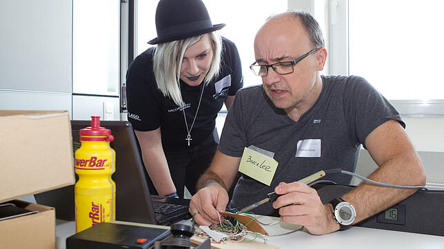 Alischa Jewko sieht Thomas Görlitz bei seinem Projekt interessiert über die Schulter.