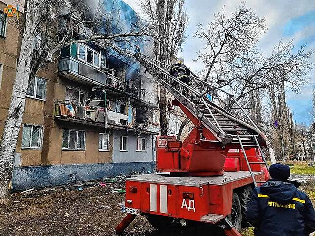 Feuerwehrleute löschen am 7. März ein Feuer in einem beschädigten Wohnhaus, nachdem russische Mehrfachraketenwerfer BM-30 Smerch das ...