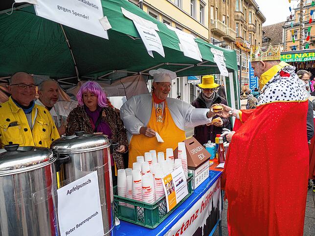 Fred Schmid (Mitte) und seine Mitstreiter von Konstanz Hilft gibt eines von hunderten Fleischkäsbrötle aus. Erbeten wird im Gegenzug ...