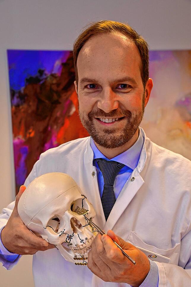 Steffen Schwarz, Leiter der Sektion Mund-, Kiefer- und Gesichtschirurgie, zeigt an einem Schädelmodell mit welchen Methoden eine ...