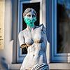 Eine Replik einer berühmten antiken Statue, der Venus von Milo, steht mit einem Mundschutz in einem Frankfurter Vorgarten.