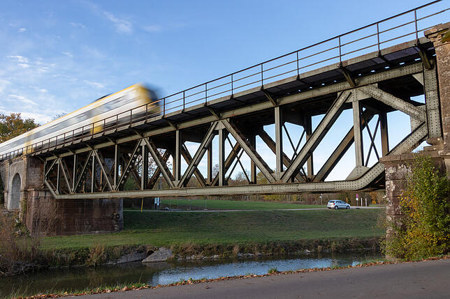 Eine Bahn fährt über die Stahlgitter-Eisenbahnbrücke von Oberlauchringen.