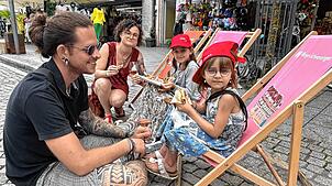 Wie am Strand: Mathilda (hinten) und Johanna genießen mit ihren Elten Lisa und Maximilian Martin leckeres Essen und kühle Getränke in ...