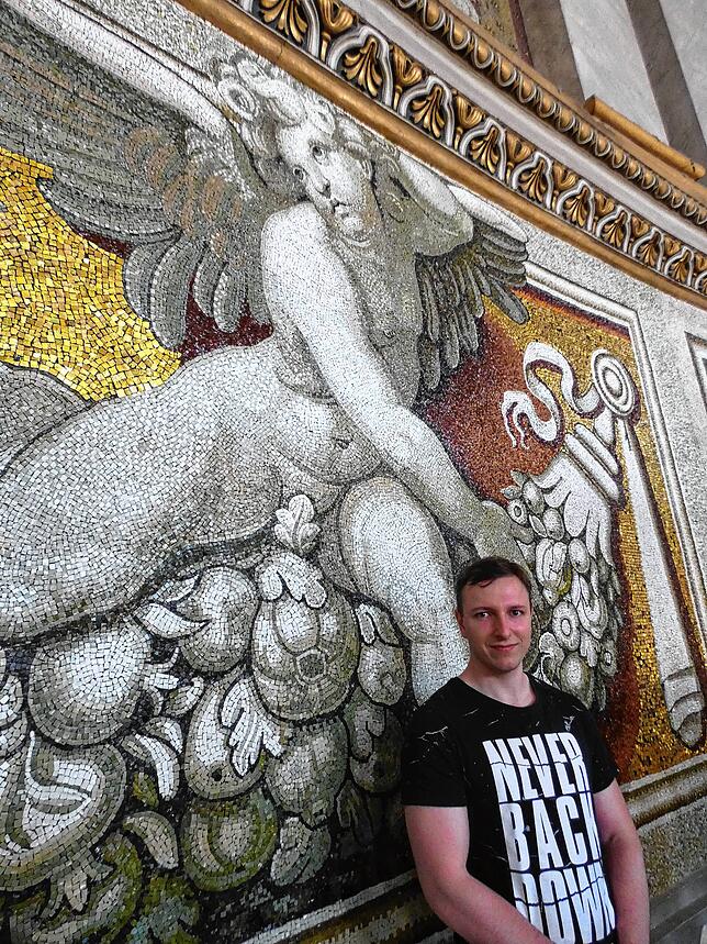 Jan Steinbeisser in Zivil auf dem Rundweg in der Kuppel des Petersdoms vor einem Mosaik.