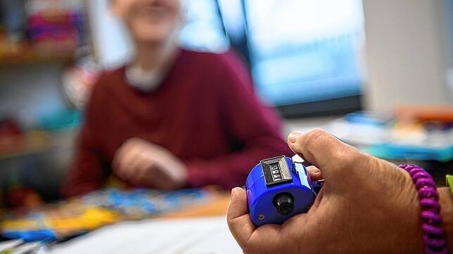 Eine Therapeutin benutzt bei der Betreuung eines autistischen Kindes einen Klicker, mit dem sie zählt, was dieses gut gemacht hat.