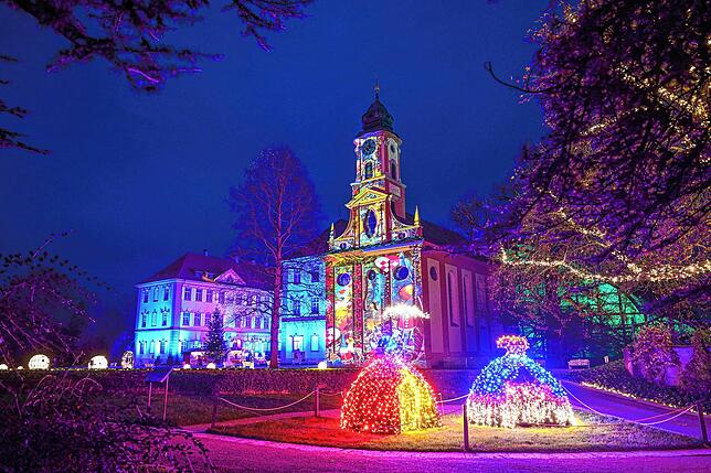 Das Schloss und die Schlosskirche St. Marien der Insel Mainau in einer lichterfrohen Farbinstallation.