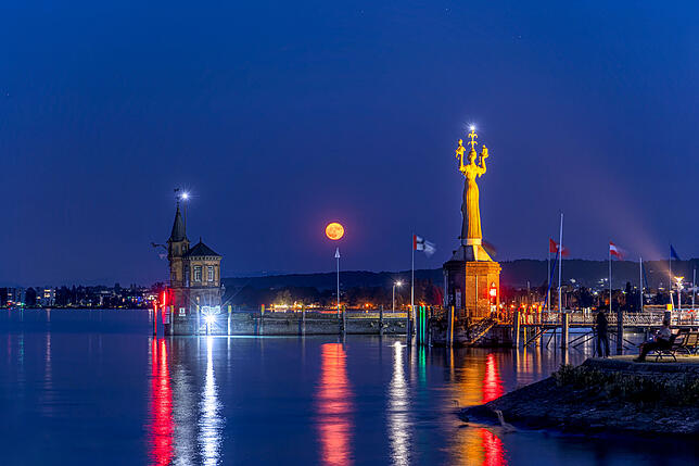 Der Erdbeermond geht am Mittwochabend vom Konstanzer Stadtgarten aus betrachtet hinter der Imperia auf.