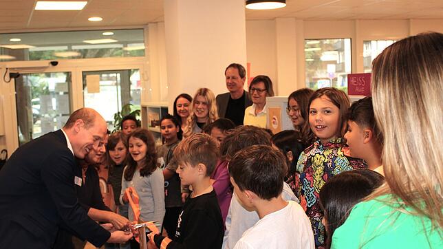 Bürgermeister Jonathan Berggötz und die Leiterin der Stadtbibliothek, Lieselotte Banhardt, schneiden vor dem Bücherregal mit den von den ...