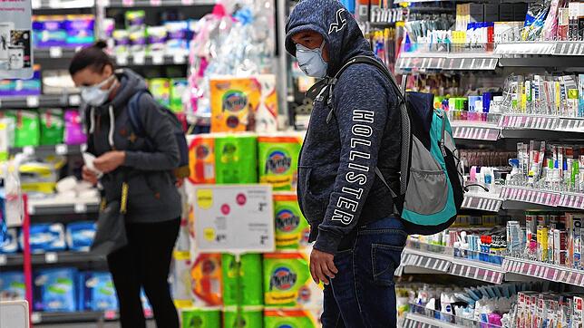 Österreich, Schwechat am 30. März 2020: Kunden mit Mundschutz kaufen in einem Supermarkt ein. Im Kampf gegen die Coronavirus-Pandemie ...