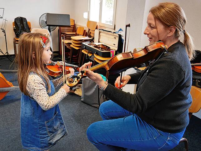 Violinlehrerin Nadja Riedl zeigt der fünfjährigen Marianne Röhl, wie man eine Geige hält.