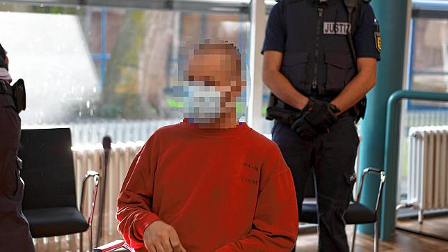 Der inzwischen 36-jährige Angeklagte sitzt unter strengen Sicherheitsvorkehrungen am Tisch im Gerichtssaal.
