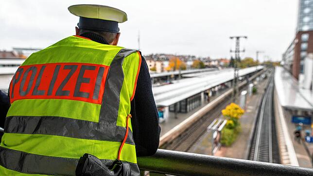 Ein Bundespolizist steht am Hauptbahnhof in Freiburg auf einer Brücke und beobachtet die Bahngleise. Die Gefahren des Bahnverkehrs ...