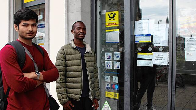 Was ist denn da los? Die Türen gehen nicht auf. So wie Namish Mishra (links) und Stephen Ouma sind viele überrascht, dass die Poststelle ...