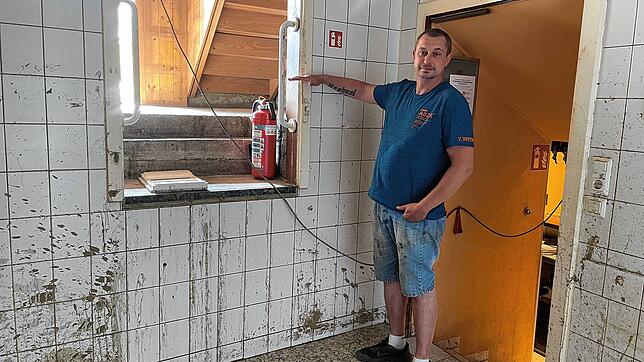 Sascha Schatz zeigt, wie hoch das Wasser in der Küche stand. Bild: Susann Duygu-D&lsquo;Souza